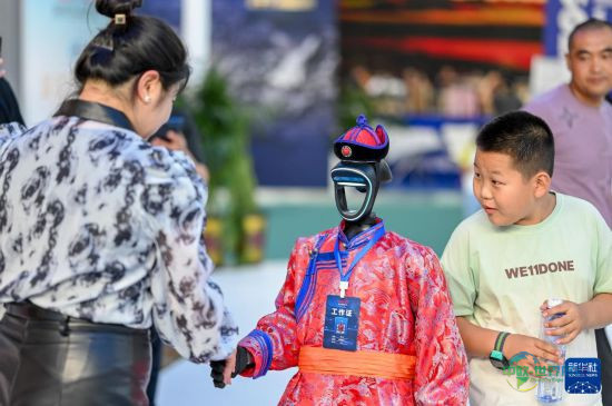 8月29日,观众在第五届中蒙博览会内蒙古展区和机器人工作人员握手。新华社记者 连振 摄